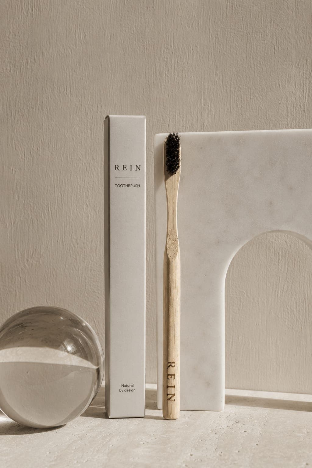 Toothbrush No. 01 next to its packaging box, against a marble arch